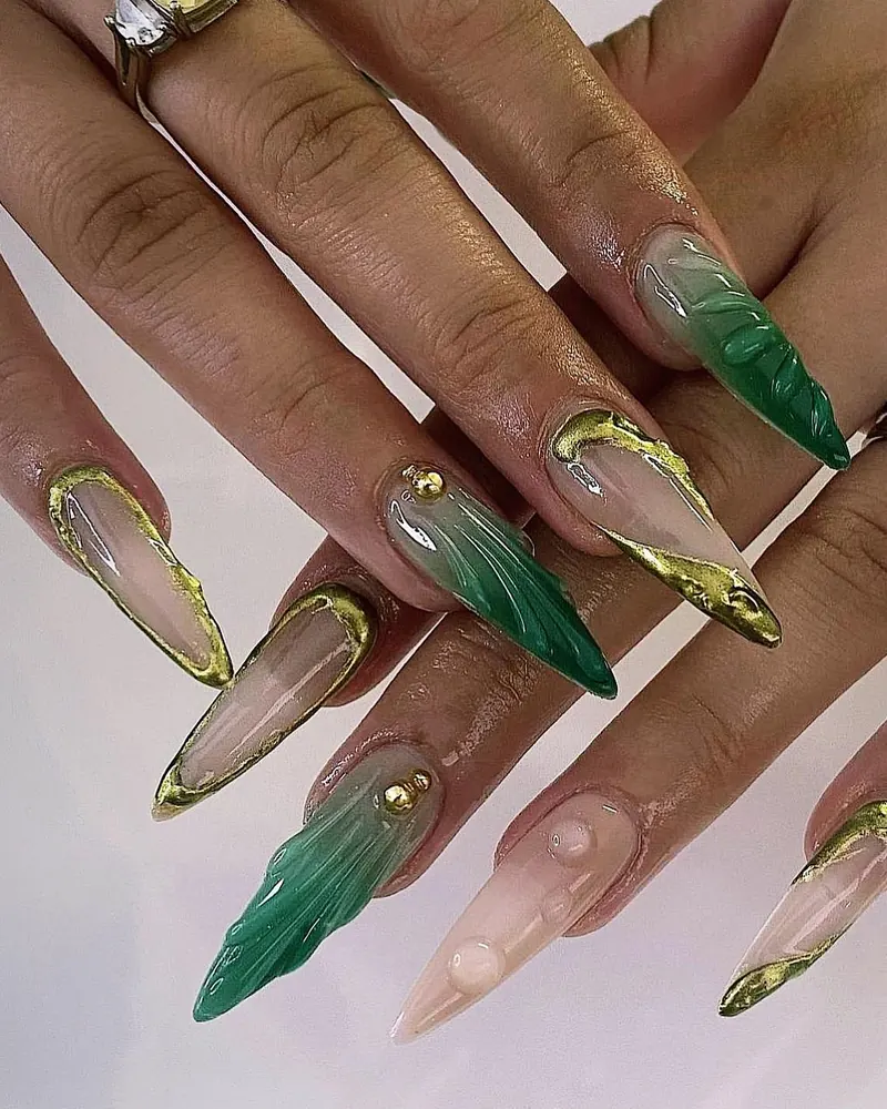Clear and emerald marble stiletto nails with raised gold chrome outlines