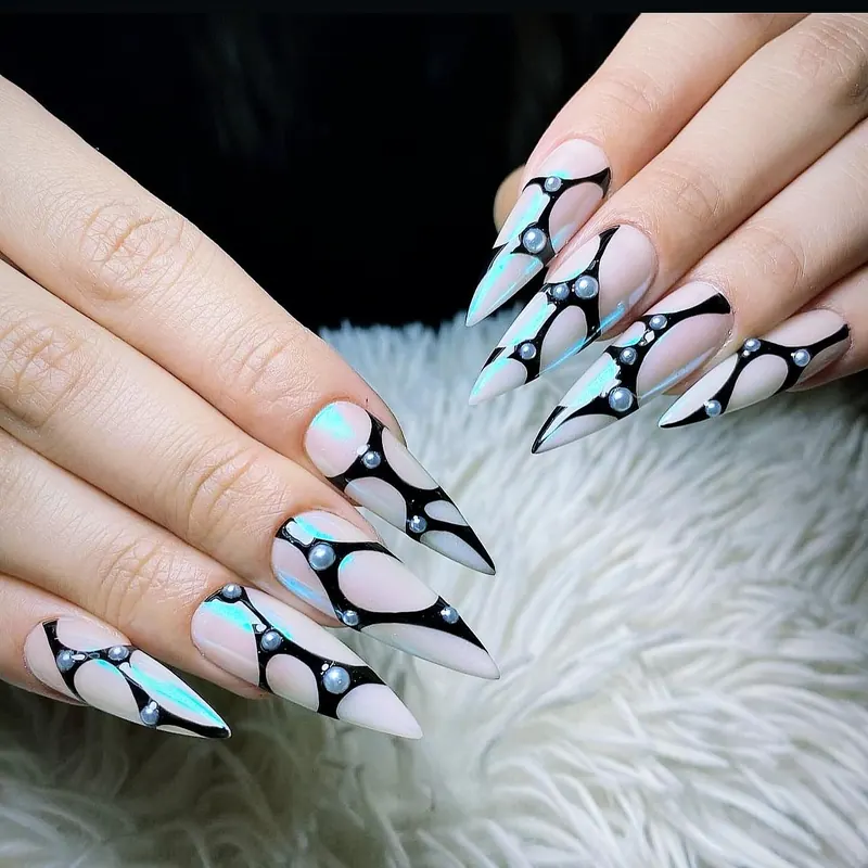 Icy blue chrome stiletto nails with black tribal lines and pearls
