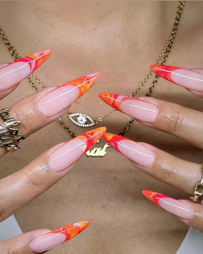 Nude stiletto nails with orange-red marble French tips