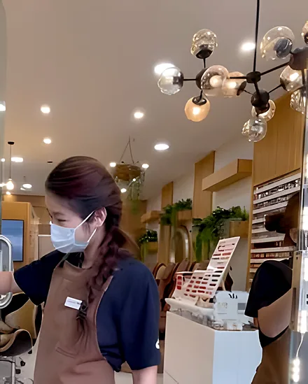 Inside Mii Nails & Lashes: glass pendant lights, the polish wall and a team member at the front desk