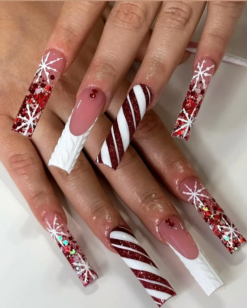 Long coffin nails with candy-cane stripes, red glitter and white snowflakes